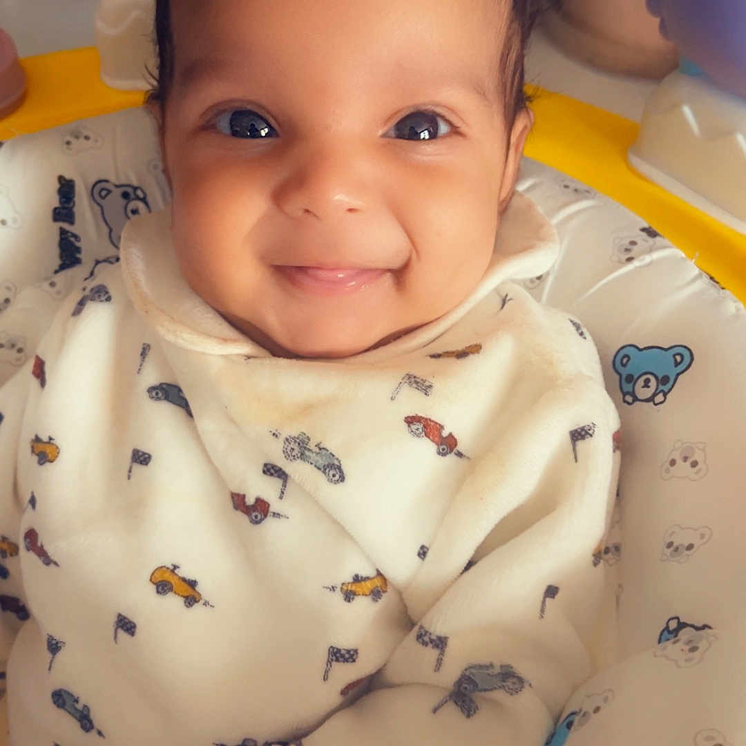 Milena participe au concours pour gagner de l'argent avec cette photo : adorable, baby, baby_seat, child, close_up, comfort, cozy, cute, face, happy, indoors, infant, onesie, patterned_clothing, portrait, sitting, smiling, soft, teddy_bear_print, young_child