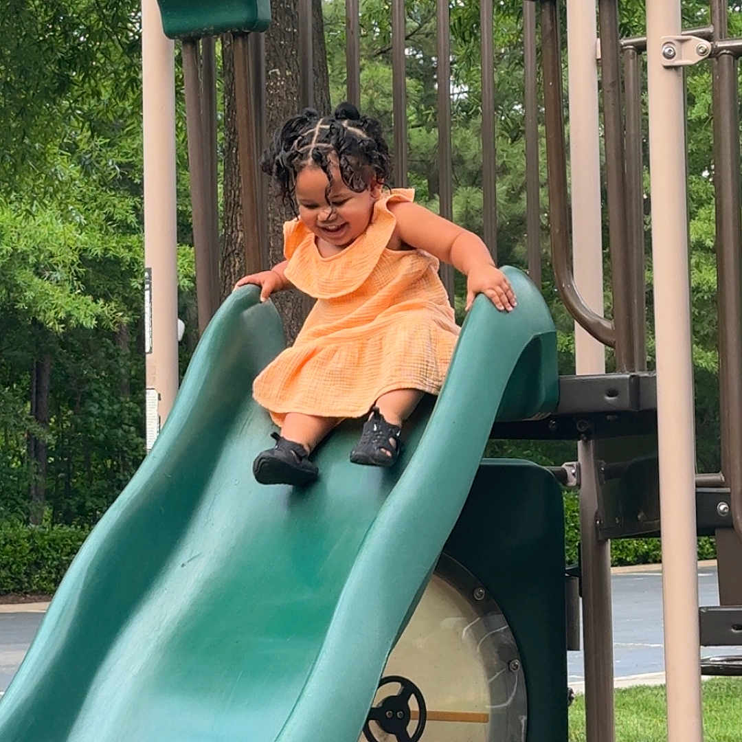 Amarie is registered to the contest to win money with this photo: child, clothing, face, female, footwear, girl, grass, head, nature, outdoorplayarea, outdoors, park, person, photography, plant, playarea, portrait, shoe, slide, toy