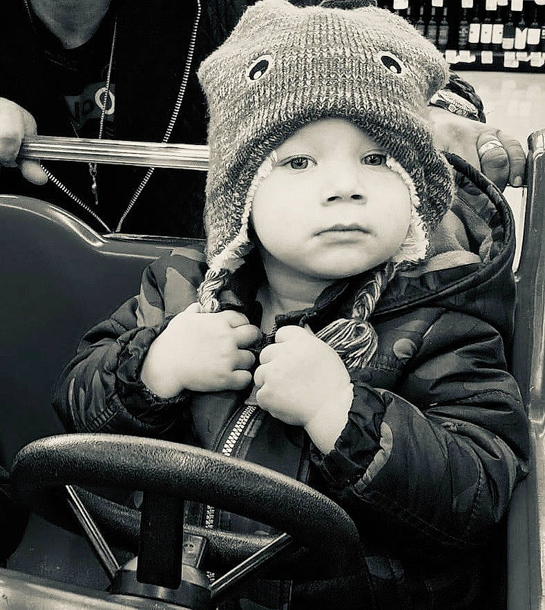 Jayden joined the competition — help win amazing prizes! baby, baby_carriage, black, black_and_white, cap, child, cool, flash_photography, fun, gesture, happy, headgear, headwear, monochrome, monochrome_photography, person, photograph, sitting, snapshot, steering_wheel
