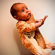 Zoé participe au concours pour gagner de l'argent avec cette photo : baby, infant, one_month, onesie, giraffe_print, hand, arm, person, portrait, curious, cute, newborn, indoor, skin, clothing, expression, human, child, holding, looking_up