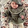 Camryn joined the competition — help win amazing prizes! baby, child, knitted_clothing, beret, cushion, animal_pattern, indoor, portrait, cute, toddler, sitting, warm_clothing, face, expression, soft_lighting, hand, foot, fabric, cozy, comfortable