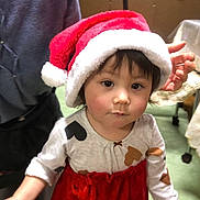 Kurumi joined the competition — help win amazing prizes! baby, child, toddler, santa_hat, christmas, holiday, portrait, indoor, smiling, facial_expression, dark_hair, brown_eyes, red_dress, festive_clothing, adult, hand, furniture, home, decorations, photography