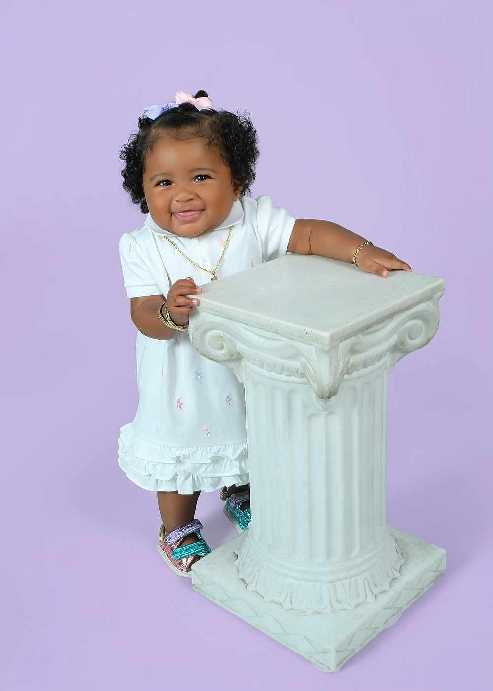 Aleah joined the competition — help win amazing prizes! toddler, child, smiling, curly_hair, bows, white_dress, bracelet, necklace, colorful_shoes, pedestal, studio, purple_background, cute, happy, standing, portrait, fashion, accessories, young_child, innocence