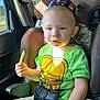 toddler, child, car_seat, party_hat, french_fry, pacifier, green_shirt, sunlight, car_interior, seatbelt, happy, blue_eyes, short_hair, sitting, casual_clothing, daylight, window, food, young_child, cute
