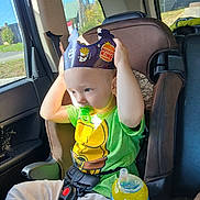 Easton joined the competition — help win amazing prizes! child, car_seat, pacifier, burger_king_crown, green_shirt, sippy_cup, car_interior, sunlight, seatbelt, toddler, window, yellow, blue, plastic, sitting, casual_clothing, daylight, young_child, portrait, curious