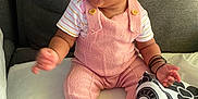 Kalycia participe au concours pour gagner de l'argent avec cette photo : baby, child, smiling, happy, pink_overalls, striped_shirt, curly_hair, sitting, indoors, couch, blanket, patterned_cloth, barefoot, cute, infant, playful, portrait, toddler, young_child, cozy