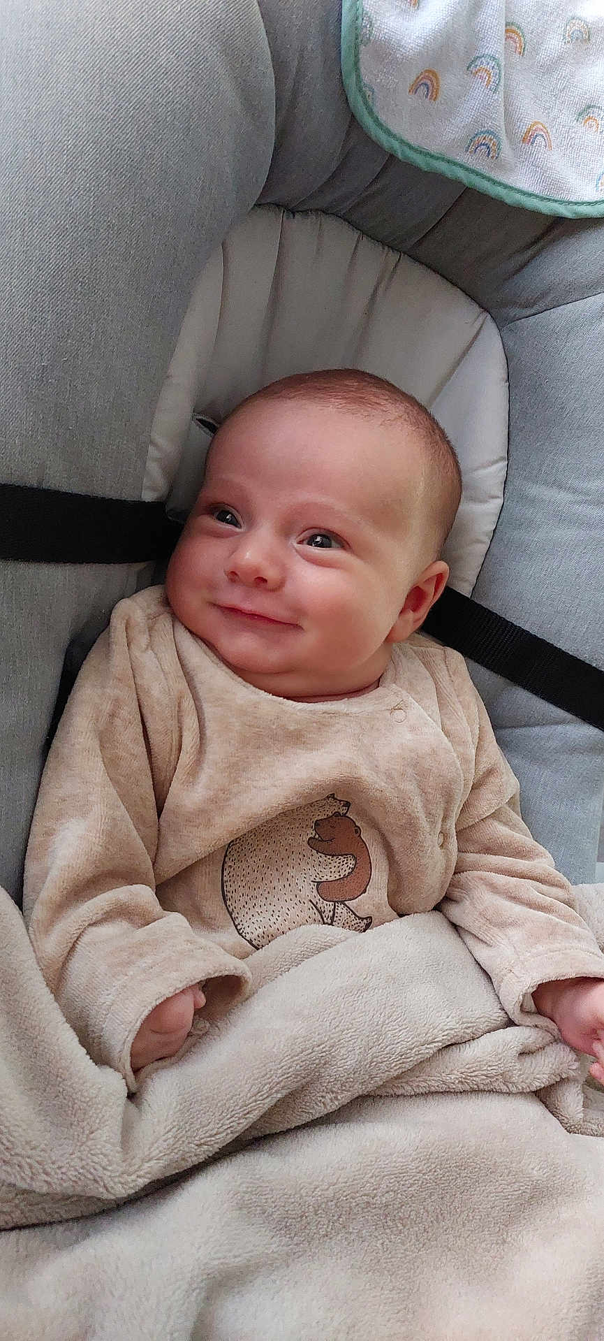 Elyo a rejoint le concours — aidez-le/la à gagner de superbes lots ! baby, infant, smile, onesie, blanket, bear_print, car_seat, strap, chubby_cheeks, hand, sleeve, bedding, soft_texture, portrait, cozy, nursery_item, gaze, skin, fabric, happy