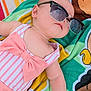 baby, child, sunglasses, swimsuit, pink_bow, striped_clothing, towel, colorful, outdoor, relaxing, cute, infant, summer, fashion, portrait, skin, arm, head, face, laying_down