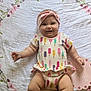 Lainey joined the competition — help win amazing prizes! baby, smiling, infant, headband, onesie, popsicle_pattern, blanket, floral, lying_down, cute, happy, child, skin, chubby_arms, chubby_legs, indoors, soft_light, pink, white, adorable