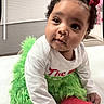 Lay Lay joined the competition — help win amazing prizes! baby, child, curly_hair, red_bow, green_outfit, red_socks, white_shirt, indoor, cute, festive, portrait, infant, sitting, curious, soft_lighting, floor, background_blur, person, toddler, holiday