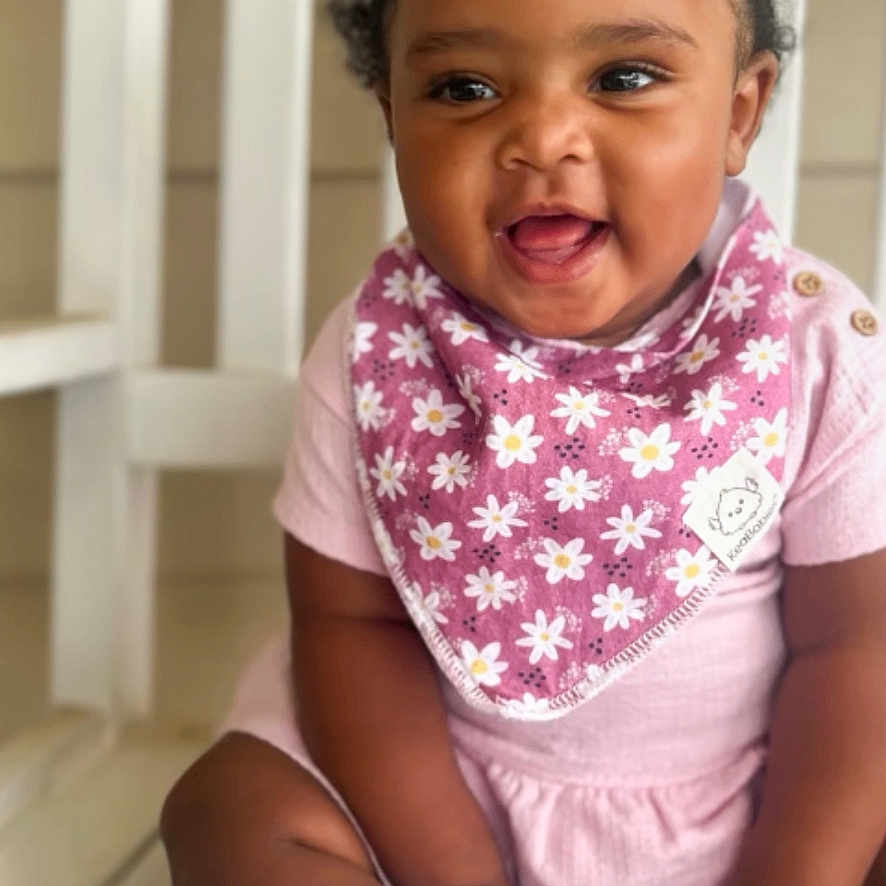 Lay Lay joined the competition — help win amazing prizes! baby, child, smiling, pigtails, pink_clothing, bib, sitting, white_socks, wooden_bench, happy, cute, portrait, indoors, infant, person, face, hair_bows, daisy_pattern, toddler, skin