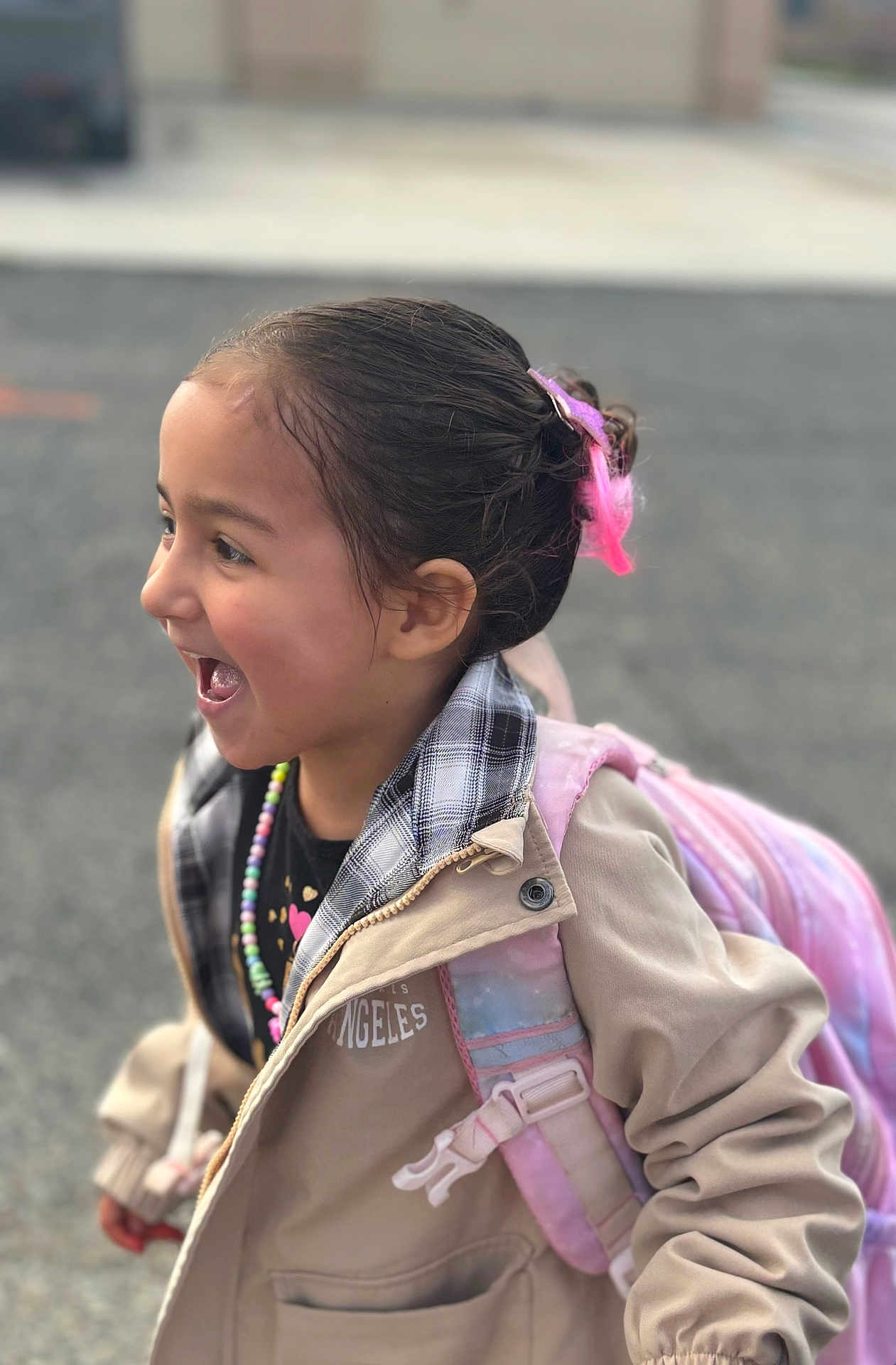 Estrella joined the competition — help win amazing prizes! backpack, beaded_necklace, beads, casual_clothing, child, cute, hair_clip, happy, jacket, joyful, kid, laughing, outdoor, pavement, person, pink, portrait, profile, smiling, young_child