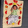 Krishvik joined the competition — help win amazing prizes! apple, arrangement, baby, child, cloth, colorful, cute, decorative, fresh, fruit, healthy, indoor, infant, lemon, lying_down, person, resting, small, traditional_clothing, watermelon