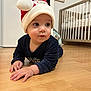 baby, child, santa_hat, floor, wooden_floor, crib, nursery, framed_artwork, hakuna_matata, indoor, clothing, long_sleeve, person, cute, holiday, festive, portrait, crawling, expression, home