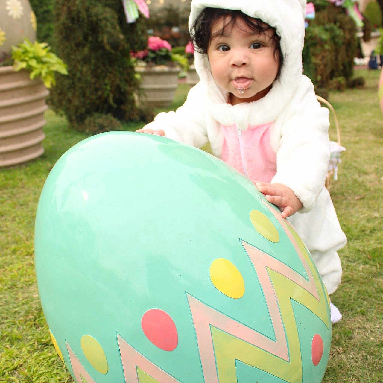 Makoa joined the competition — help win amazing prizes! baby, balloon, bonnet, clothing, coat, face, flower, grass, hat, head, hood, jacket, knitwear, outdoors, person, photography, plant, portrait, purple, sphere