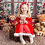 child, girl, teddy_bear, red_dress, holiday, christmas, smile, blonde_hair, headband, plush_toy, gift, wooden_crate, fur_trim, window, snow, christmas_tree, decorations, carpet, floor, portrait