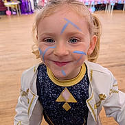Aria Robinson joined the competition — help win amazing prizes! child, face_paint, smiling, indoor, party, costume, blonde_hair, curly_hair, blue_eyes, wooden_floor, people, background, celebration, young, portrait, happy, clothing, jacket, event, fun