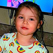 Charlena St. Angelo is registered to the contest to win money with this photo: background, casual, child, clothing, colorful, expression, face, hair, head, indoor, light, person, portrait, rainbow_pattern, screen, shirt, sitting, television, wall, young
