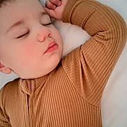 Alexander is registered to the contest to win money with this photo: toddler, child, sleeping, face, closed_eyes, brown_clothing, ribbed_fabric, arm, hand, soft_texture, blanket, rest, peaceful, portrait, indoor, cozy, cute, baby, skin, head