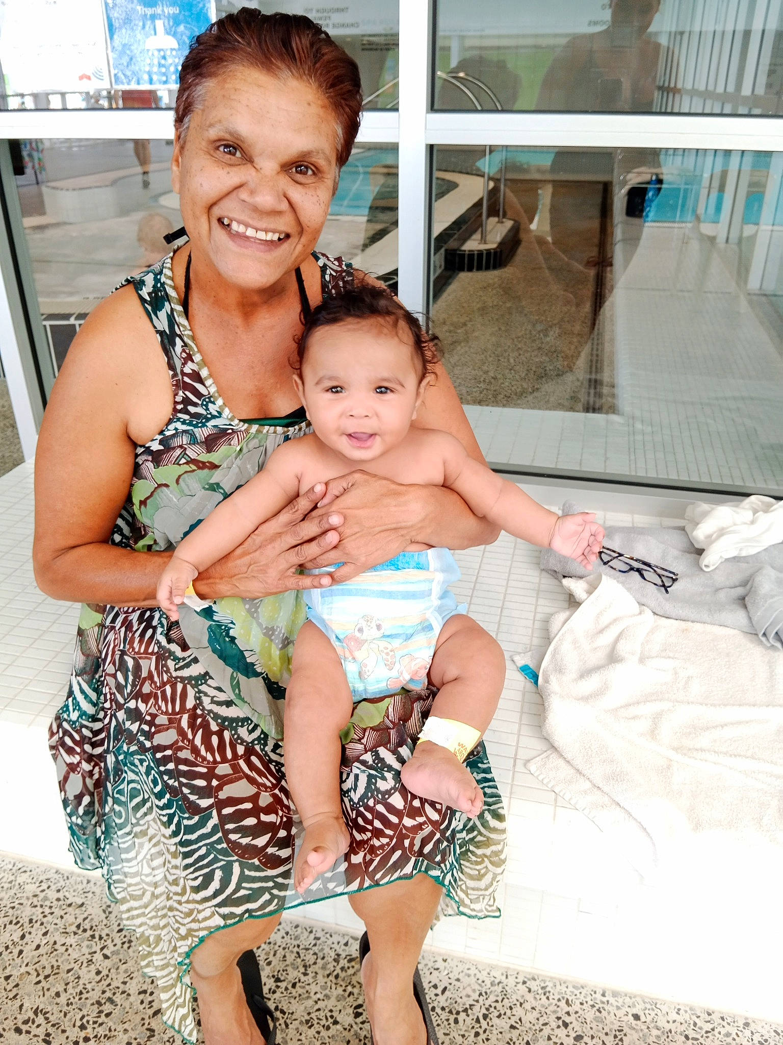 Kelvin is registered to the contest to win money with this photo: baby, barefoot, chair, event, fun, happy, head, human_leg, interaction, joy, leg, leisure, muscle, person, shoulder, sitting, skin, smile, swimwear, thigh