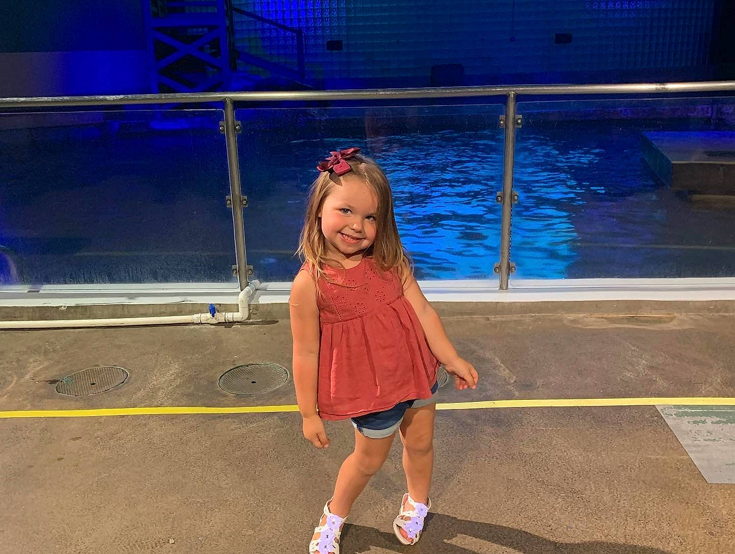 Callie is registered to the contest to win money with this photo: boot, electric_blue, entertainment, event, eyewear, fashion_design, flooring, fun, happy, human_leg, joy, leisure, magenta, night, person, recreation, smile, swimming_pool, t_shirt, toddler