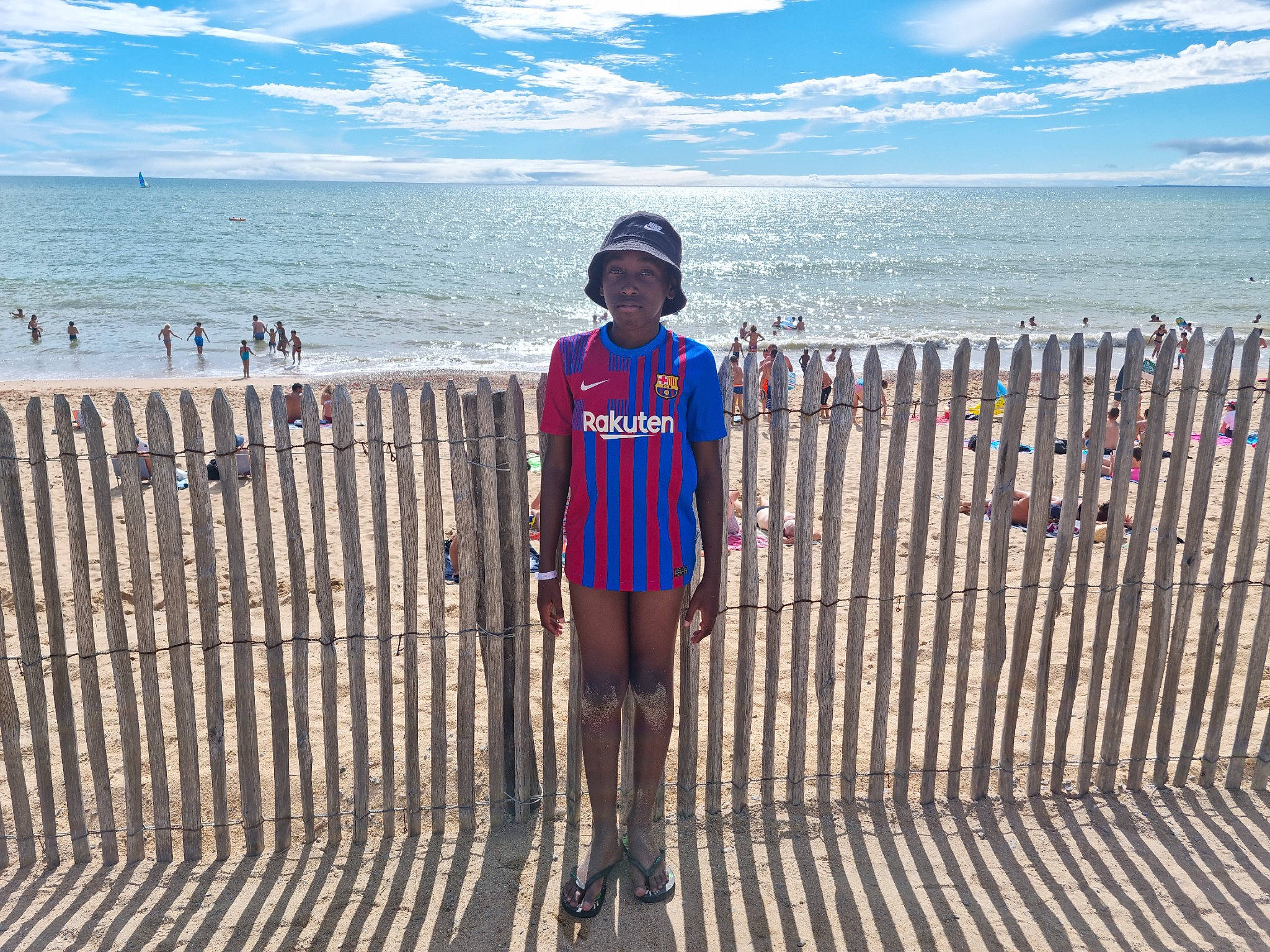 Pharell a rejoint le concours — aidez-le/la à gagner de superbes lots ! azure, beach, cloud, coast, electric_blue, fence, hat, headwear, horizon, leisure, natural_environment, person, sand, shore, shorts, sky, standing, summer, t_shirt, travel