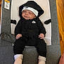 baby, infant, nike, hoodie, hat, socks, baby_rocker, gray, white, black_clothing, indoor, footwear, cute, child, resting, portrait, smile, person, apparel, relaxing