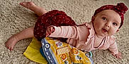 Aphelia Kay joined the competition — help win amazing prizes! baby, infant, headband, pink_clothing, red_headband, carpet, toy, playful, crawling, child, cute, indoor, smiling, face, hands, feet, colorful, fabric, soft, young