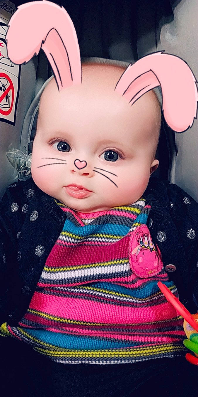 Ninon a rejoint le concours — aidez-le/la à gagner de superbes lots ! baby, brown_hair, cheek, child, doll, ear, eye, face, forehead, head, iris, lip, nose, outerwear, person, pink, skin, smile, toddler, toy