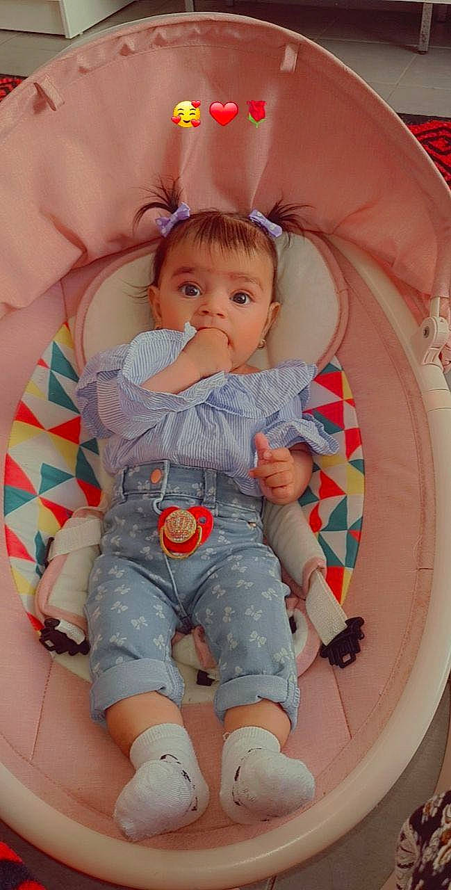 Betty Anays a rejoint le concours — aidez-le/la à gagner de superbes lots ! baby, baby_toddler_clothing, chair, child, comfort, facial_expression, finger, fun, knee, lap, leg, mouth, orange, organ, person, pink, product, skin, sneakers, surprise