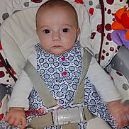 Manon a rejoint le concours — aidez-le/la à gagner de superbes lots ! baby, infant, child, chicco, car_seat, baby_seat, safety_harness, dress, patterned_clothing, toy, colorful, indoor, person, face, wide_eyes, seated, cute, young, expression, hands