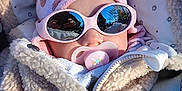 Manon participe au concours pour gagner de l'argent avec cette photo : baby, infant, sunglasses, pacifier, hat, jacket, polka_dot, pink, beige, cozy, outdoor, reflection, sunlight, child, cute, warm_clothing, face, baby_accessory, winter_wear, portrait