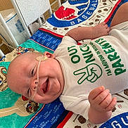 Asher joined the competition — help win amazing prizes! baby, smiling, infant, blanket, baseball, onesie, face, hand, nasal_cannula, hospital, cute, child, lying_down, happy, clothing, toddler, indoor, person, baby_boy, bed