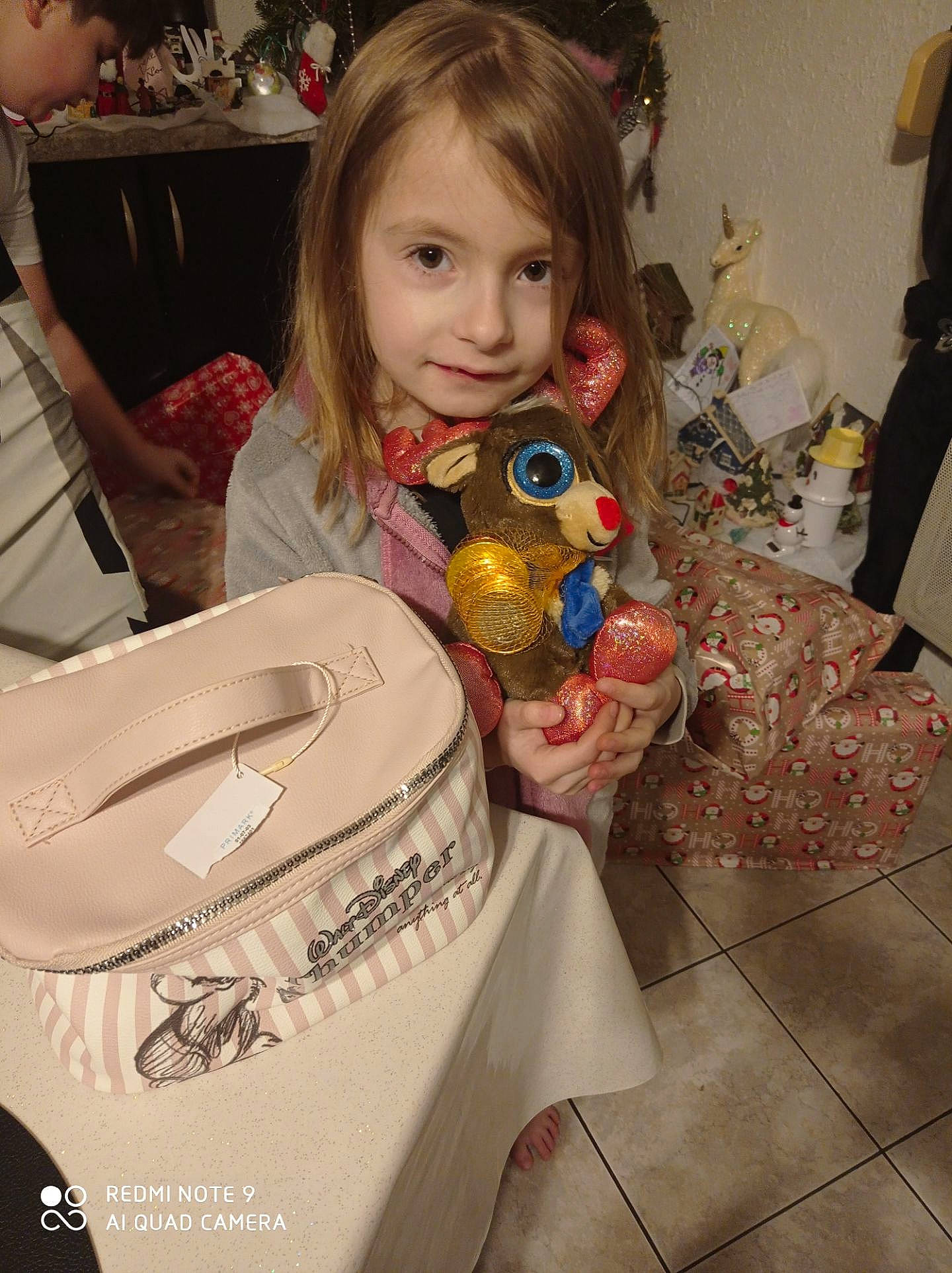 Edeen a rejoint le concours — aidez-le/la à gagner de superbes lots ! bag, beauty, child, christmas_eve, event, facial_expression, flooring, fun, hairstyle, happy, holiday, iris, pattern, people, person, present, room, sitting, smile, toddler