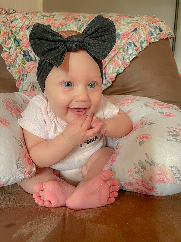 Brynleigh is registered to the contest to win money with this photo: baby, baby_toddler_clothing, cheek, child, comfort, eye, face, fashion_accessory, foot, happy, headgear, headwear, human_leg, joy, linens, lip, pattern, person, pink, skin
