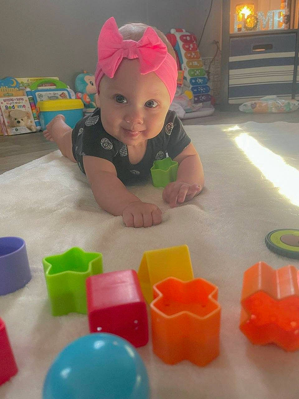 Brynleigh is registered to the contest to win money with this photo: baby, baby_laughing, baby_playing_with_toys, baby_products, baby_toddler_clothing, baby_toys, cap, child, event, flooring, fun, headwear, leisure, party_supply, person, plastic, play, room, smile, sweetness