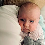 Arya participe au concours pour gagner de l'argent avec cette photo : baby, blanket, closeup, clothing, cute, expression, face, glove, gray, head, indoor, infant, newborn, pale_skin, pink, portrait, sleepwear, soft_texture, warm, white