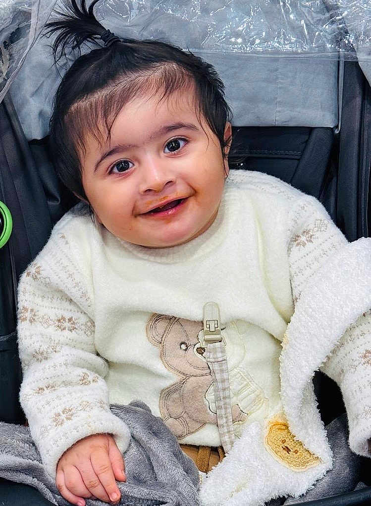 Darbjot joined the competition — help win amazing prizes! baby, blanket, child, clothing, cozy, cute, face, hand, happy, indoors, infant, person, pony_tail, portrait, smiling, stroller, sweater, teddy_bear, toddler, warm