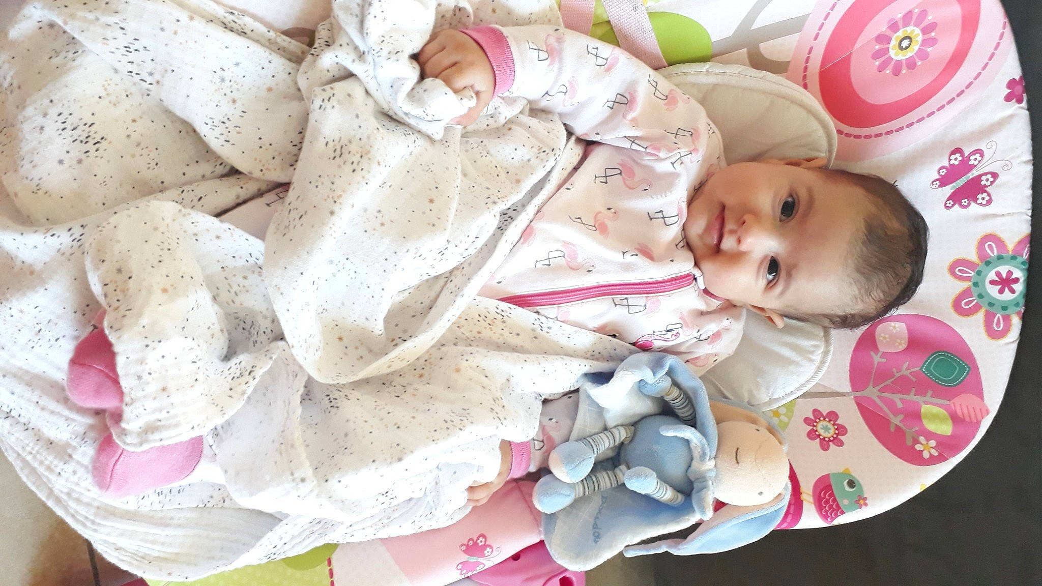 Mila participe au concours pour gagner de l'argent avec cette photo : baby, baby_products, baby_toddler_clothing, carmine, cheek, child, comfort, fashion_accessory, happy, headgear, linens, logo, pattern, peach, person, petal, pink, room, skin, sleeve