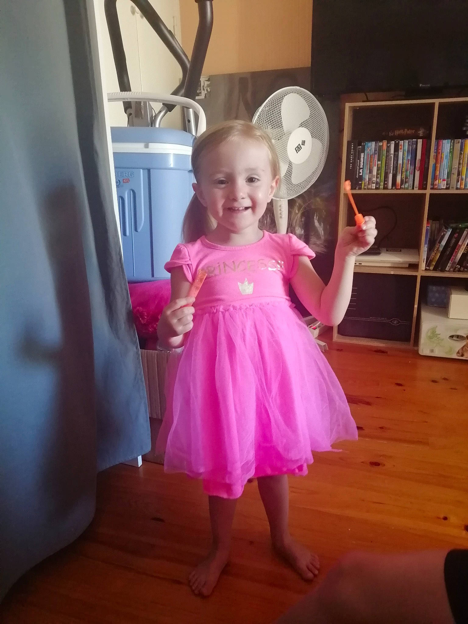 Taïna a rejoint le concours — aidez-le/la à gagner de superbes lots ! baby_toddler_clothing, bookcase, clothing, day_dress, dress, face, flooring, fun, hand, happy, iris, joy, one_piece_garment, person, pink, purple, shelf, shelving, smile, toddler