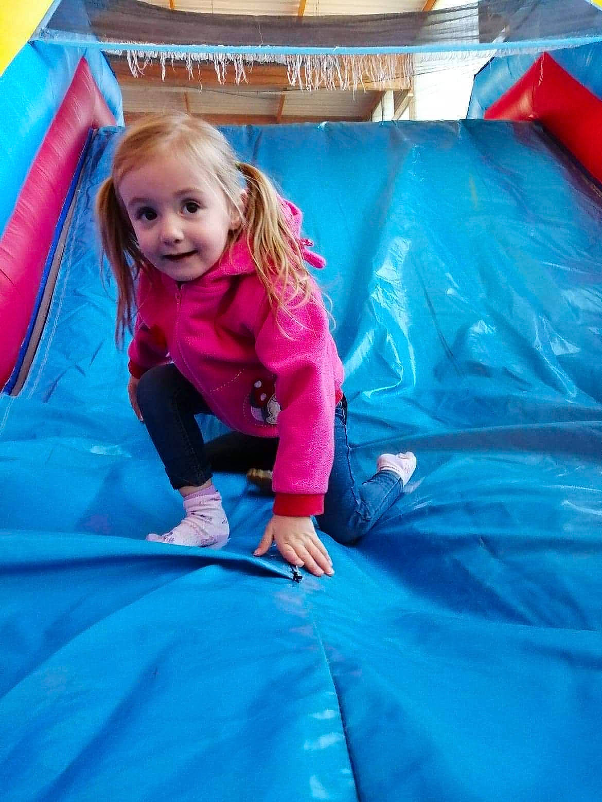 Taïna participe au concours pour gagner de l'argent avec cette photo : blue, bounce_house, chute, comfort, electric_blue, fun, grass, happy, joy, leisure, magenta, mouth, outdoor_play_equipment, outdoor_recreation, person, playground, purple, recreation, sitting, smile