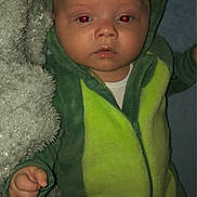 Junior joined the competition — help win amazing prizes! baby, infant, dinosaur_onesie, green_clothing, blanket, red_eye, cute, child, portrait, indoor, soft_texture, cozy, sleepwear, hooded_outfit, small_hand, lying_down, face, person, expressionless, newborn