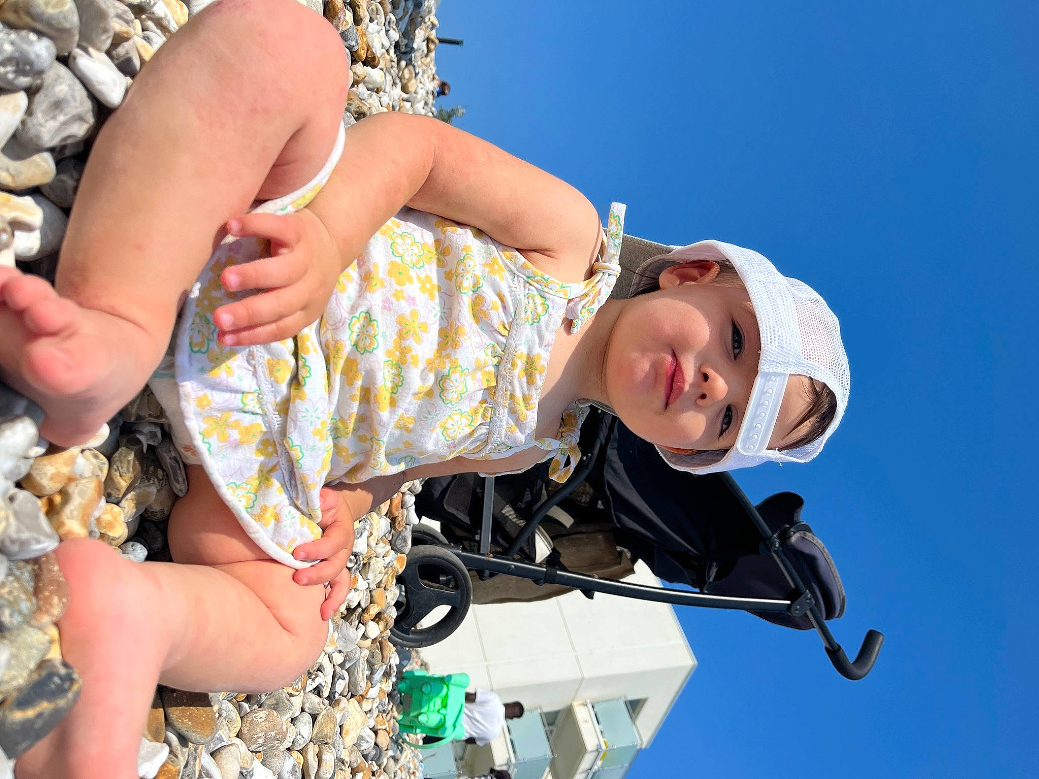 Eliza joined the competition — help win amazing prizes! child, eyewear, fun, grass, happy, hat, headwear, human_leg, leisure, nail, pattern, people_in_nature, person, recreation, sandal, shorts, sitting, sky, thigh, toddler