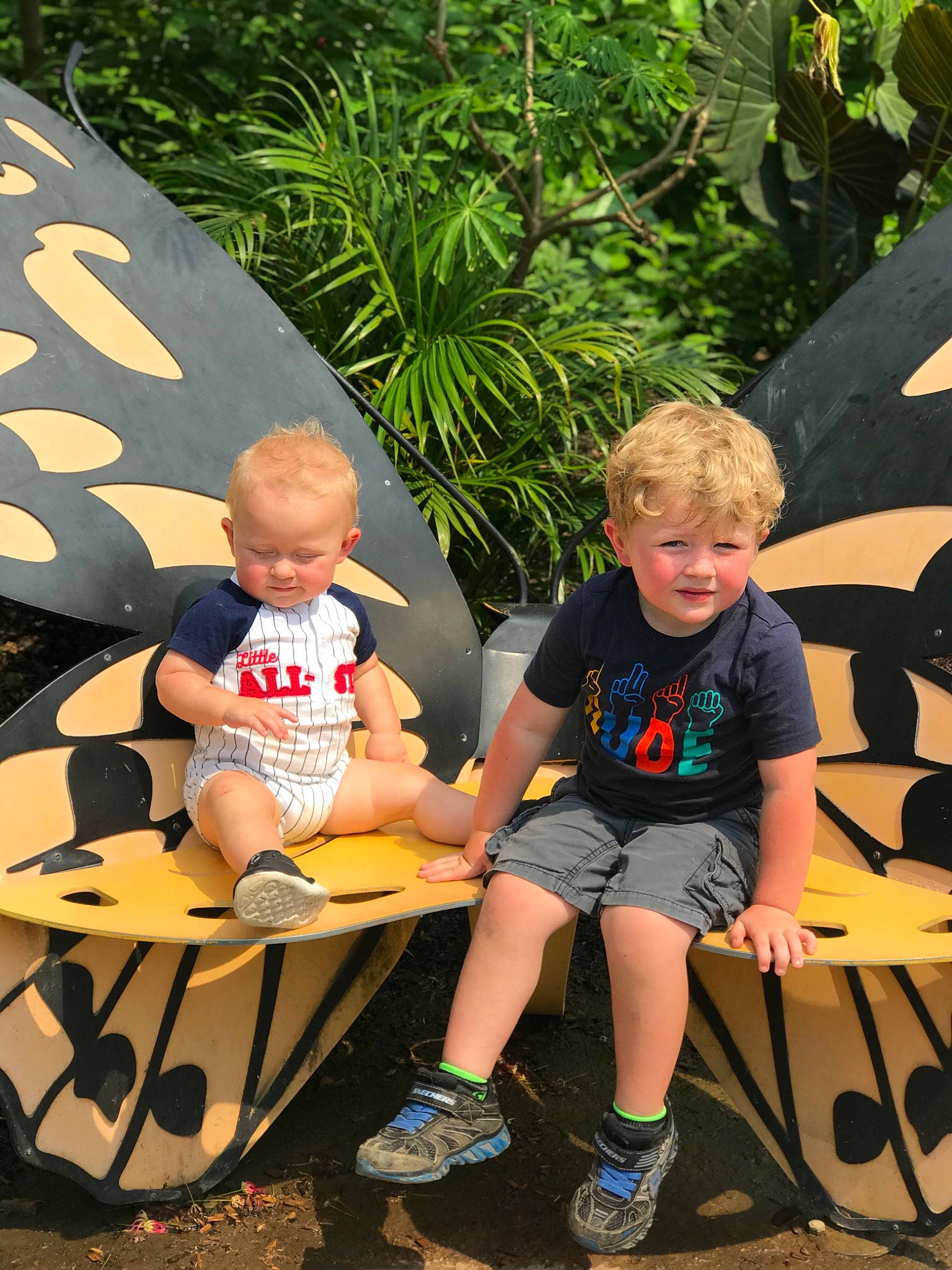 Carter is registered to the contest to win money with this photo: child, event, fun, grass, happy, lap, leaf, leisure, person, plant, play, recreation, sandal, shade, shorts, sitting, sneakers, style, t_shirt, toddler