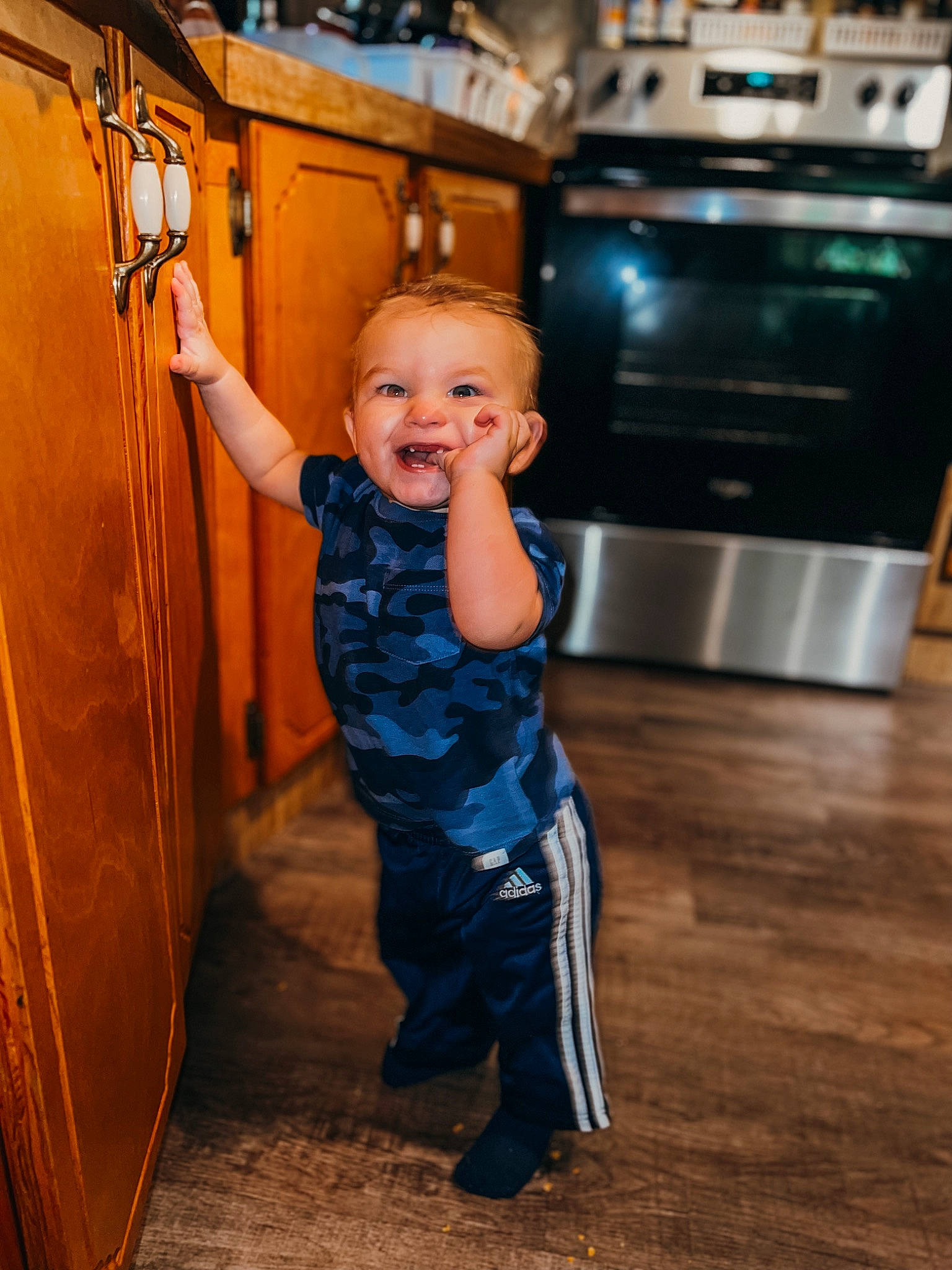 Kamden joined the competition — help win amazing prizes! cabinetry, countertop, electric_blue, floor, flooring, fun, happy, hardwood, home_appliance, kitchen_appliance, kitchen_stove, laminate_flooring, leisure, person, shoulder, smile, standing, stove, t_shirt, toddler