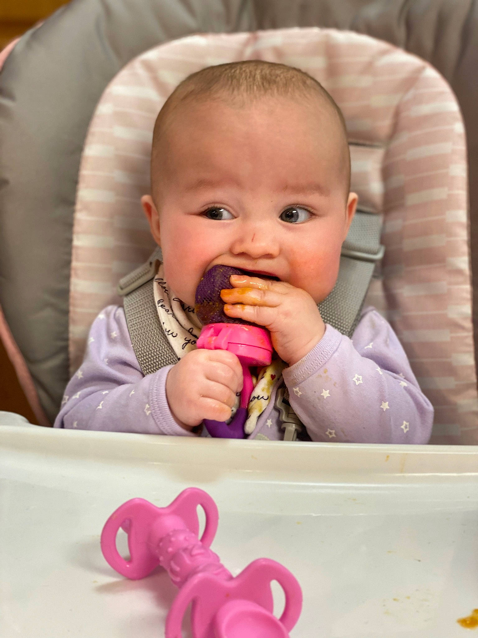 Kaykay is registered to the contest to win money with this photo: baby, baby_toddler_clothing, biting, chair, cheek, child, eye, face, facial_expression, finger, food_craving, head, lip, mouth, nose, organ, person, pink, product, skin