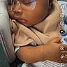 baby, infant, sleeping, sunglasses, hat, knit_hat, blanket, swaddled, portrait, close_up, face, eyes_closed, peaceful, indoor, seated, car_seat, clothing, striped_outfit, smartphone_screenshot, social_media