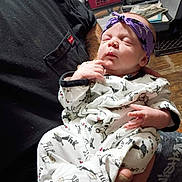 Lilith joined the competition — help win amazing prizes! newborn, baby, headband, onesie, animal_print, sleeping, person, indoor, hands, clothing, fabric, holding, cozy, basket, floor, tattoo, arm, purple, white, pattern