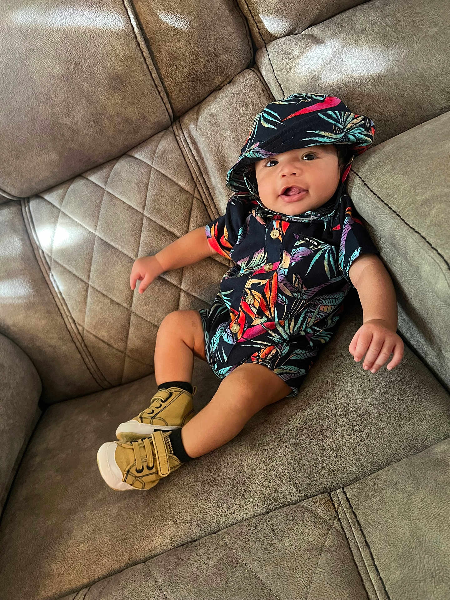 Josiah joined the competition — help win amazing prizes! baby, child, toddler, couch, sofa, clothing, hat, shoes, footwear, smile, happy, indoor, fabric, patterned, cute, young, relaxing, person, portrait, casual