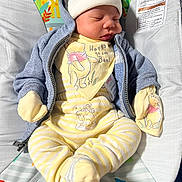 Josiah is registered to the contest to win money with this photo: baby, sleeping, pajamas, mittens, hat, hoodie, baby_seat, yellow_stripes, soft_toys, peaceful, infant, child, clothing, cute, resting, indoor, comfort, patterned, closeup, portrait